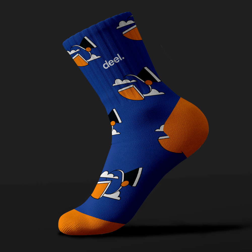 AI Startups 24 Blue sock with an orange heel and toe, featuring a cartoon graphic of a person with a hat and sunglasses against a dark background. The word deel. is printed near the top, showcasing unlimited graphic design creativity.
